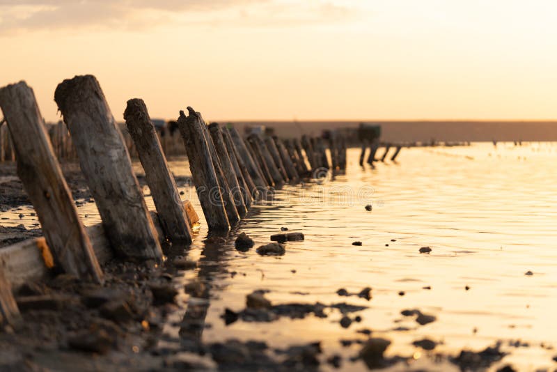Sonnenuntergang auf dem Kuyalnik Liman odessa ukraine Alte Klotz sind vom wasser- die Überreste eines alten Piers sichtbar lizenzfreies stockfoto Sonnenuntergang auf dem Kuyalnik Liman odessa ukraine Alte Klotz sind vom wasser- die Überreste eines alten Piers sichtbar lizenzfreies stockfoto