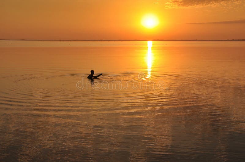 Sonnenuntergang auf dem Meer, das Schattenbild eines Mannes lizenzfreies stockbild Sonnenuntergang auf dem Meer, das Schattenbild eines Mannes lizenzfreies stockbild