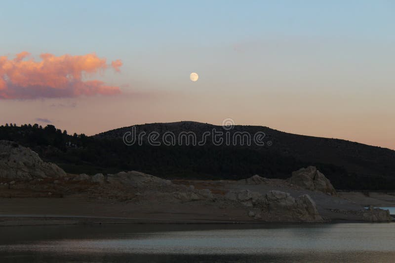 Sonnenuntergang mit Vollmond über See stockbild Sonnenuntergang mit Vollmond über See stockbild