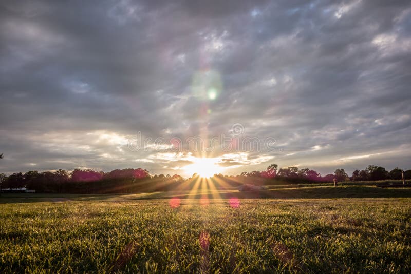 Sonnenuntergang über grünem Bauernhoffeld lizenzfreie stockfotografie