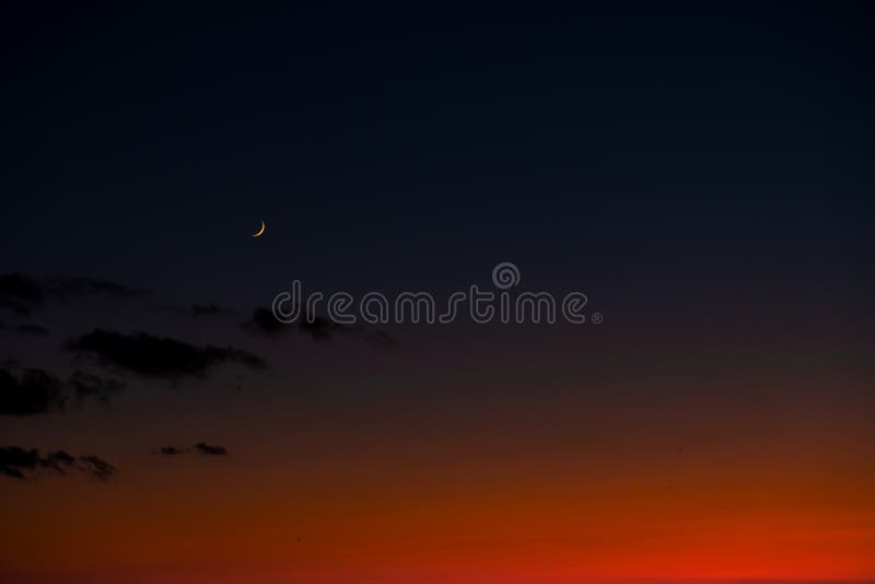 Sonnenunterganghimmel mit hellem rotem Horizont und Halbmond moon stockbild Sonnenunterganghimmel mit hellem rotem Horizont und Halbmond moon stockbild