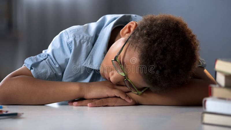 Sono cansado do aluno, sentando-se na mesa, processo educacional duro, menino sobrecarregado imagem de stock Sono cansado do aluno, sentando-se na mesa, processo educacional duro, menino sobrecarregado imagem de stock