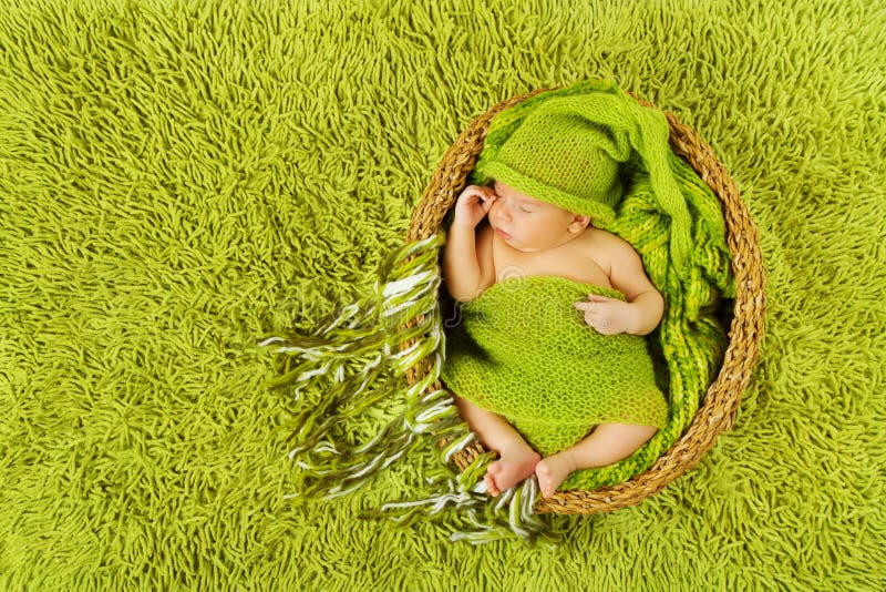 Sono recém-nascido do bebê no chapéu de lã, tapete verde imagem de stock royalty free Sono recém-nascido do bebê no chapéu de lã, tapete verde imagem de stock royalty free