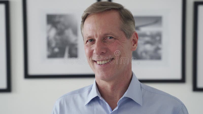 Sonriente hombre de 50 años mirando a cámara en casa retrato de disparo de cabeza. almacen de video