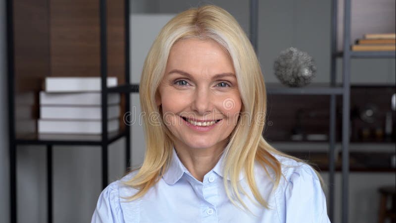 Sonriente segura mujer de negocios de mediana edad mira el retrato de la cámara. almacen de metraje de vídeo