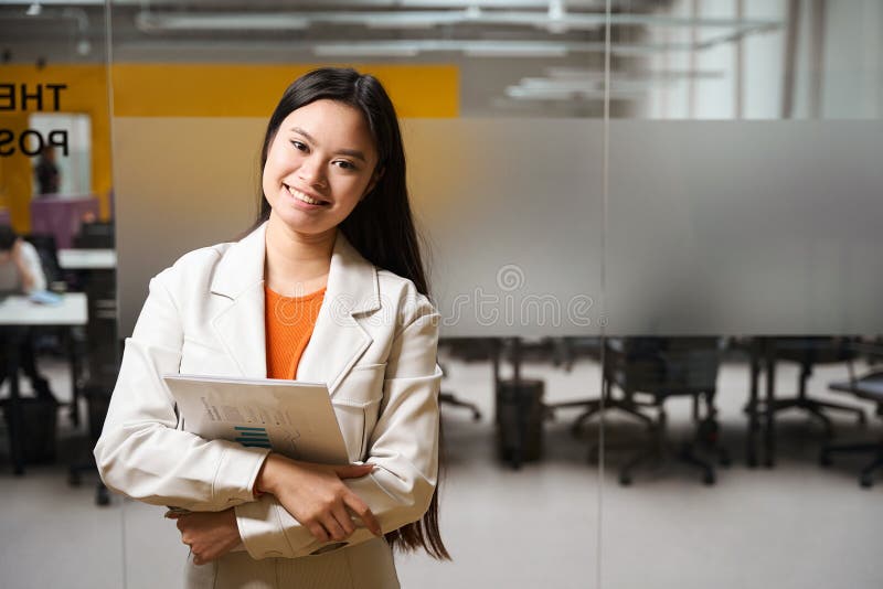 Sonriente y feliz empleado de la empresa posando para la cámara en una oficina moderna fotos de archivo libres de regalías