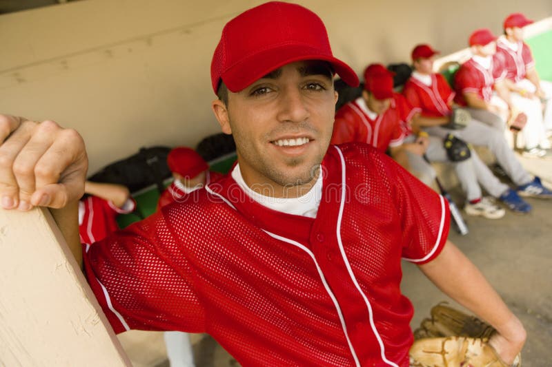 Portrait of a baseball player smiling with team in background. Portrait of a baseball player smiling with team in background