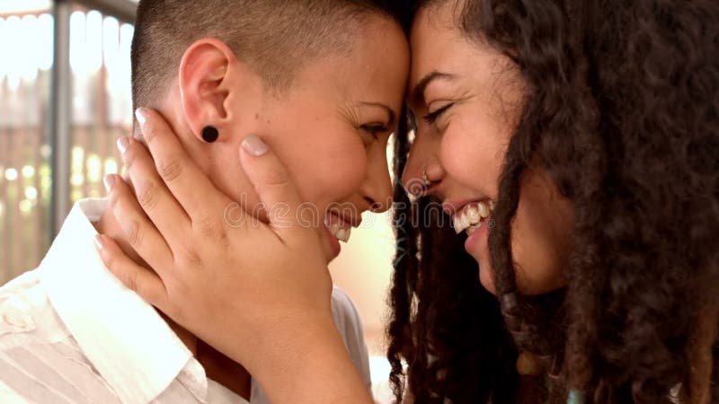 Sonrisa lesbiana feliz de los pares cara a cara