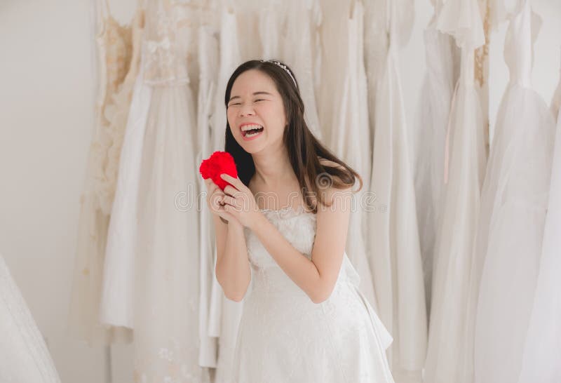 Sonrisa y mano asiáticas de la mujer de la novia hermosa joven feliz que llevan a cabo el corazón rojo modelo imagen de archivo libre de regalías Sonrisa y mano asiáticas de la mujer de la novia hermosa joven feliz que llevan a cabo el corazón rojo modelo imagen de archivo libre de regalías