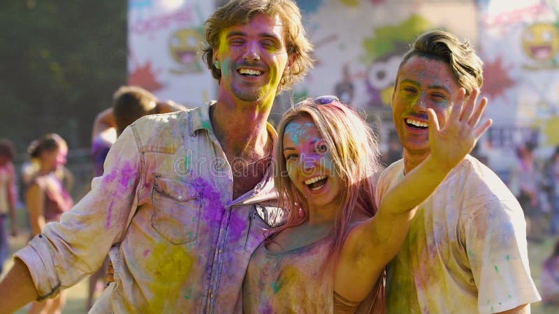 Sonrisas en las caras felices de la gente joven que disfruta de festival indio tradicional del holi almacen de video