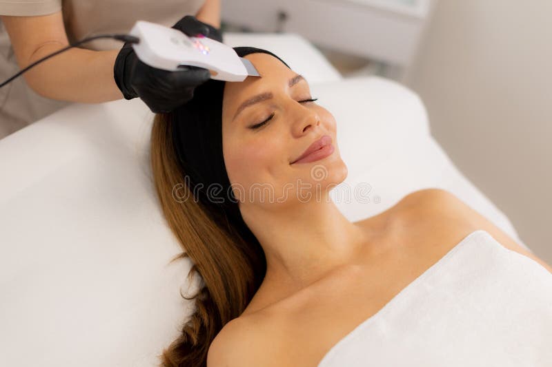 Soothing vibrations from the ultrasonic facial massager create a rejuvenating experience as the expert skincare professional cleanses and revitalizes the client’s radiant complexion. Pampering experience stock images, royalty-free photos and pictures