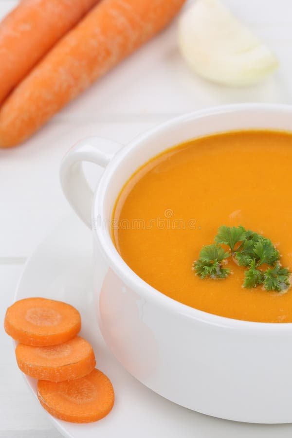 Sopa da cenoura com as cenouras frescas no close up da bacia fotografia de stock Sopa da cenoura com as cenouras frescas no close up da bacia fotografia de stock