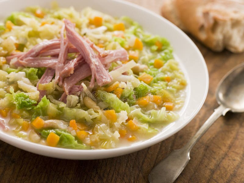 Cabbage and Bacon Soup with Rustic Bread on table with spoon. Cabbage and Bacon Soup with Rustic Bread on table with spoon