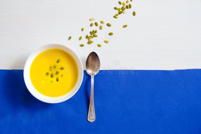 Sopa de las semillas de la calabaza y de girasol en una placa blanca con las cucharas de plata en un fondo brillante El concepto imagenes de archivo Sopa de las semillas de la calabaza y de girasol en una placa blanca con las cucharas de plata en un fondo brillante El concepto imagenes de archivo