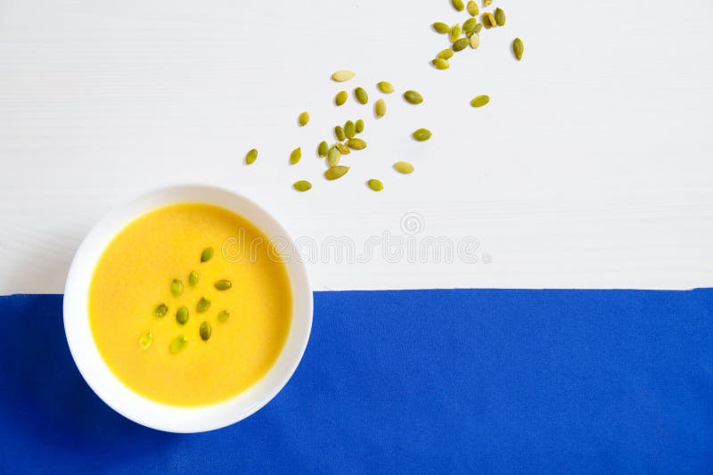 Sopa de las semillas de la calabaza y de girasol en una placa blanca en un fondo brillante El concepto de consumición sana, pérdi fotografía de archivo Sopa de las semillas de la calabaza y de girasol en una placa blanca en un fondo brillante El concepto de consumición sana, pérdi fotografía de archivo