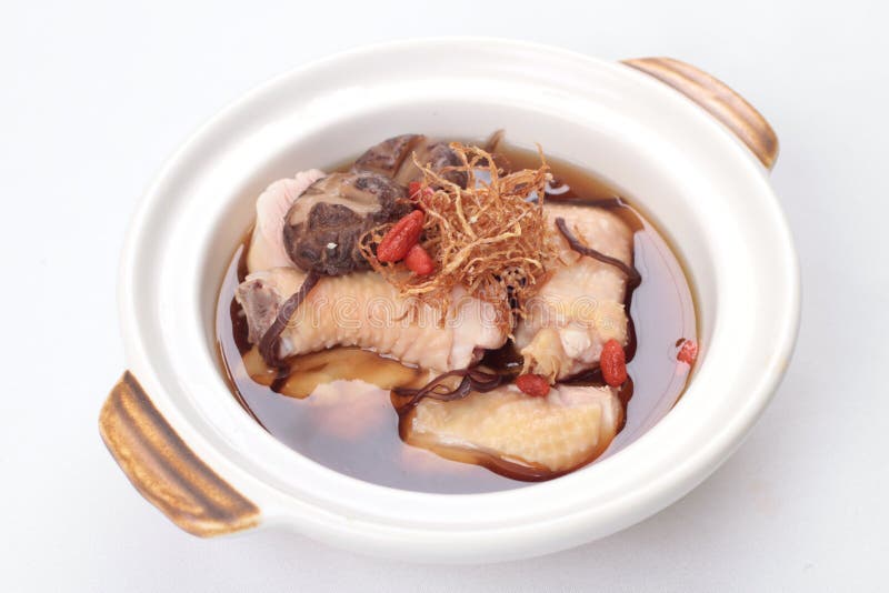 Traditional Chinese herbal soup cooked with free range chicken, mushrooms, wolf berries and topped with fried ginger slices and served in a clay pot. Traditional Chinese herbal soup cooked with free range chicken, mushrooms, wolf berries and topped with fried ginger slices and served in a clay pot