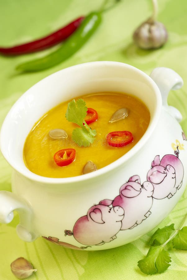 White pot with Ñream soup from pumpkin and carrots with hot pepper and seeds. White pot with Ñream soup from pumpkin and carrots with hot pepper and seeds