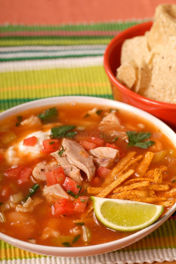 Bowl of chicken and tortilla soup with lime and chips. Bowl of chicken and tortilla soup with lime and chips