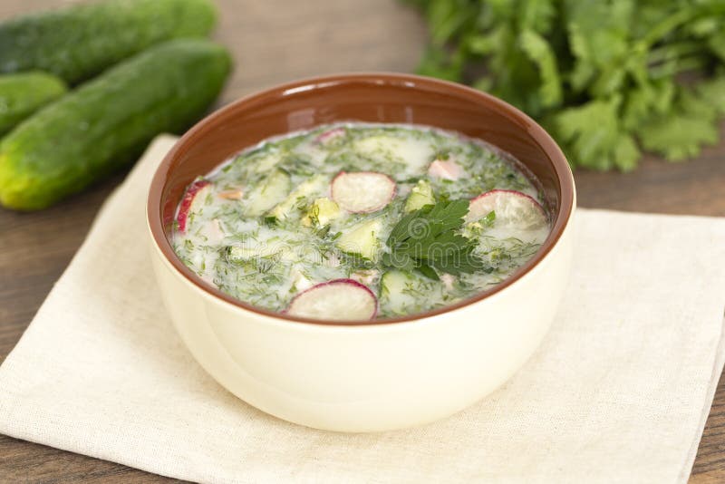 Sopa fría del yogur del verano con el rábano, el pepino, y el eneldo en la tabla de madera Sopa de verduras fría rusa en el yogur imagen de archivo Sopa fría del yogur del verano con el rábano, el pepino, y el eneldo en la tabla de madera Sopa de verduras fría rusa en el yogur imagen de archivo
