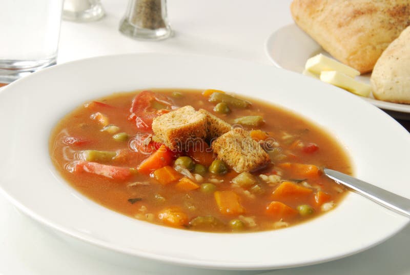 A bowl of steaming vegetable beef soup with barley. A bowl of steaming vegetable beef soup with barley