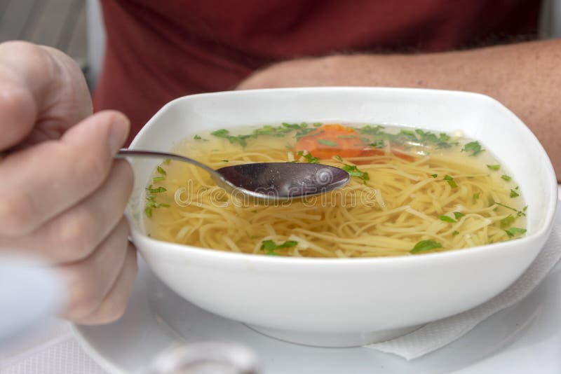 Sopa vegetal deliciosa com os macarronetes na bacia branca, colher de aço inoxidável à disposição, pronto para comer fotografia de stock royalty free Sopa vegetal deliciosa com os macarronetes na bacia branca, colher de aço inoxidável à disposição, pronto para comer fotografia de stock royalty free