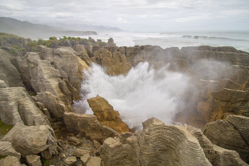 Sopladura grande en las rocas de la crepe en la costa oeste de Nueva Zelandia fotografía de archivo libre de regalías Sopladura grande en las rocas de la crepe en la costa oeste de Nueva Zelandia fotografía de archivo libre de regalías