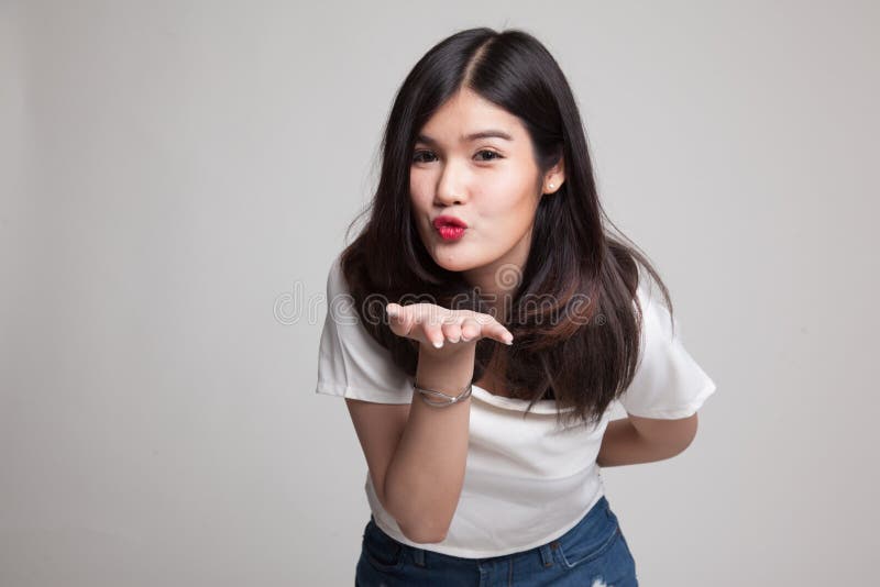 Soplo asiático joven hermoso de la mujer un beso fotografía de archivo libre de regalías Soplo asiático joven hermoso de la mujer un beso fotografía de archivo libre de regalías