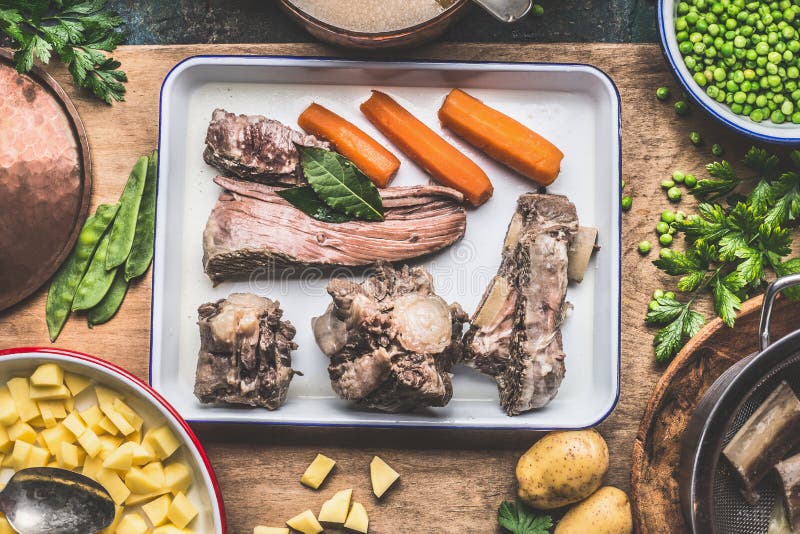 Soppamatlagningförberedelse med lagat mat kött, grönsaker, potatisar och gröna ärtor på det lantliga köksbordet arkivfoto Soppamatlagningförberedelse med lagat mat kött, grönsaker, potatisar och gröna ärtor på det lantliga köksbordet arkivfoto