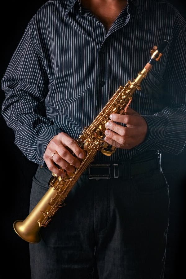 Soprano Saxophone in the Hands of a Guy on a Black Background Stock