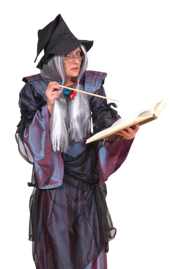 Halloween witch with magic wand reading spells in book. holiday festive costume dressed woman. Halloween witch with magic wand reading spells in book. holiday festive costume dressed woman