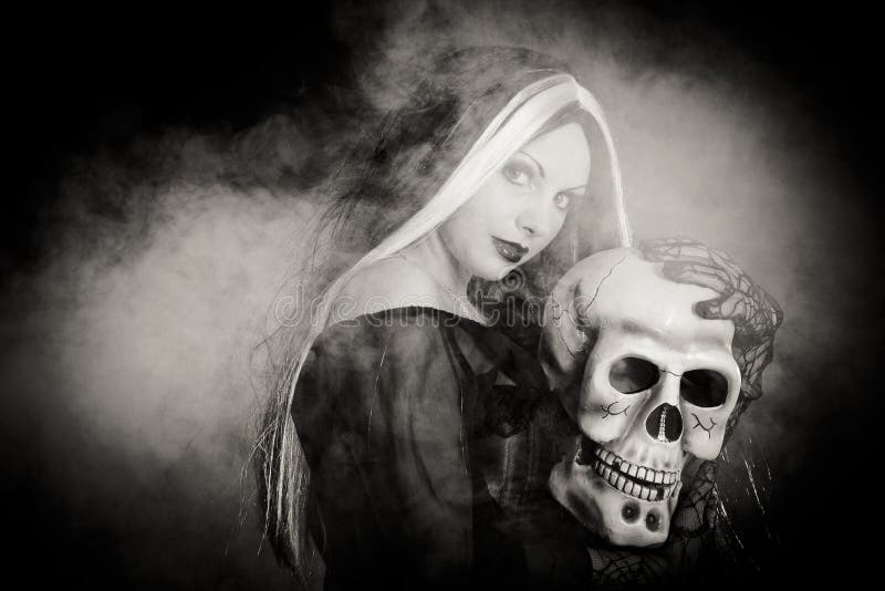 Sorcière de Veille de la toussaint avec un crâne photo libre de droits Sorcière de Veille de la toussaint avec un crâne photo libre de droits