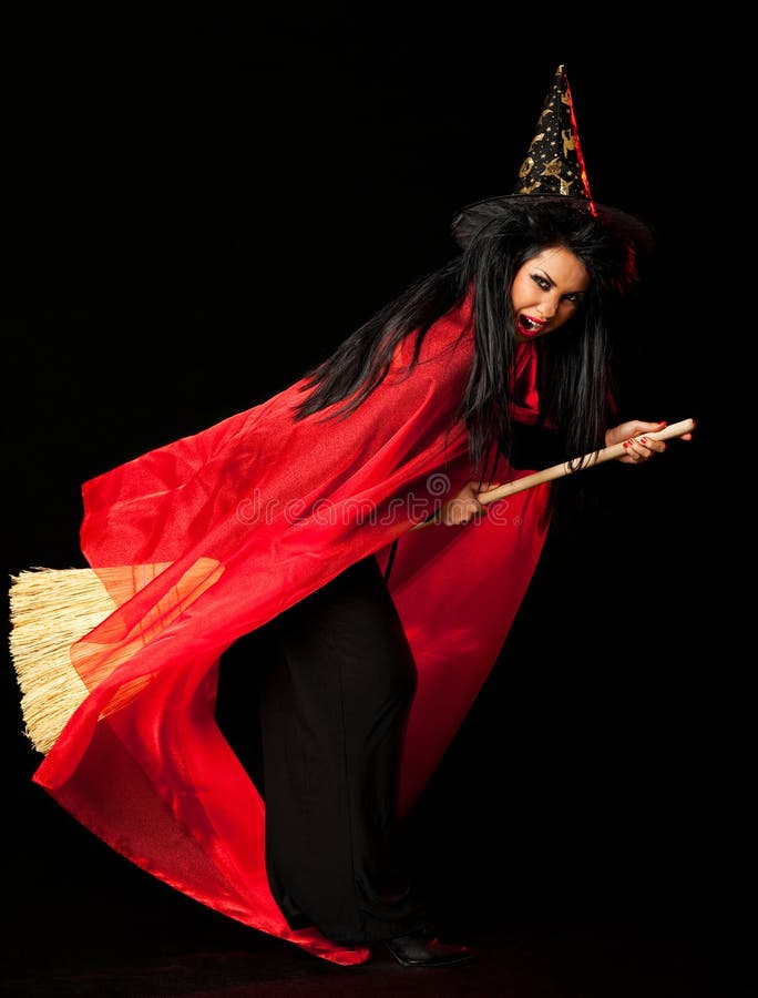Witch with a red cloak, hat and a broom between her legs. Witch with a red cloak, hat and a broom between her legs