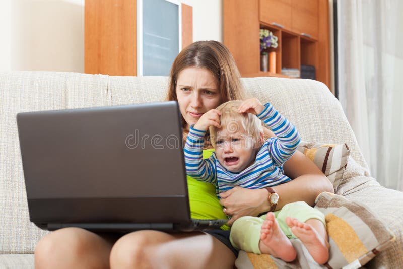 Sorehead mother with crying baby working online