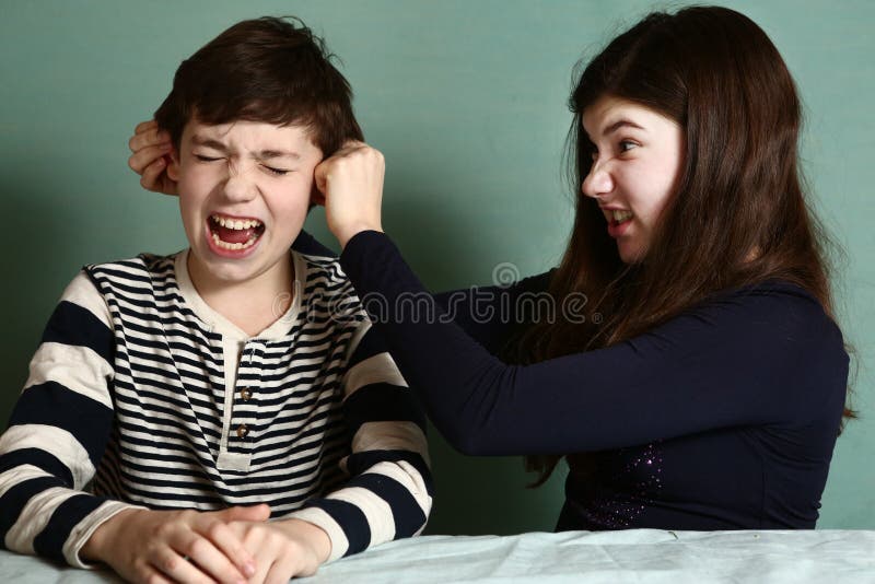 Sorella orecchio del fratello di tirata come perdita nella discussione fotografia stock libera da diritti Sorella orecchio del fratello di tirata come perdita nella discussione fotografia stock libera da diritti