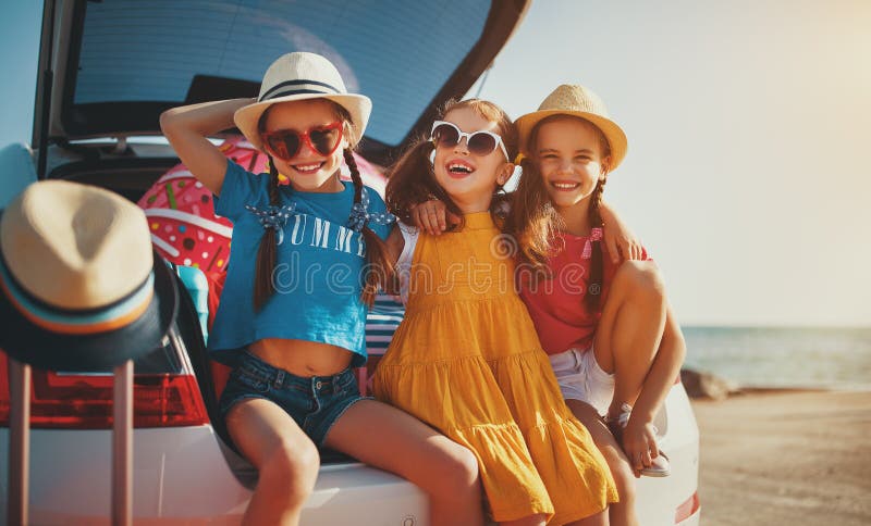 Sorelle felici degli amici di ragazze dei bambini sul giro dell'automobile al viaggio di estate fotografia stock libera da diritti Sorelle felici degli amici di ragazze dei bambini sul giro dell'automobile al viaggio di estate fotografia stock libera da diritti