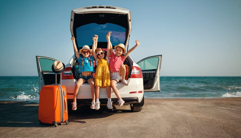 Sorelle felici degli amici di ragazze dei bambini sul giro dell'automobile al viaggio di estate immagini stock Sorelle felici degli amici di ragazze dei bambini sul giro dell'automobile al viaggio di estate immagini stock
