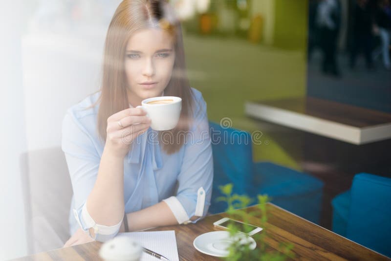 Sorglig kvinna i coffee shop fotografering för bildbyråer Sorglig kvinna i coffee shop fotografering för bildbyråer