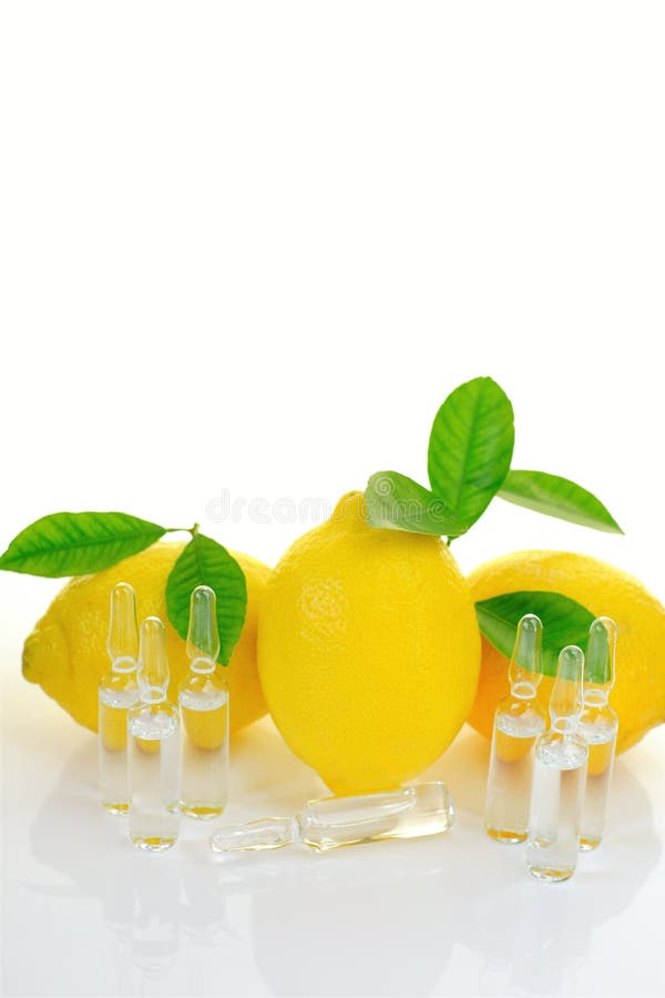 Soro de vitamina com vitamina c. ampolas transparentes juntam limões frutos com folhas verdes sobre fundo branco com