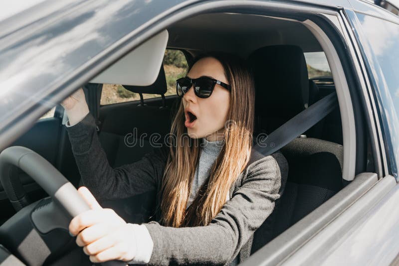 Sorprenden o se asustan a la muchacha o al conductor en el coche foto de archivo Sorprenden o se asustan a la muchacha o al conductor en el coche foto de archivo