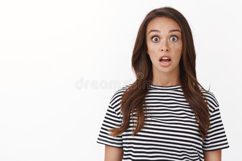 Sorprendida guapa morena sin habla con la mandíbula de la camiseta a rayas que cae de asombro, la cámara fija ve impresionante pr imagen de archivo libre de regalías
