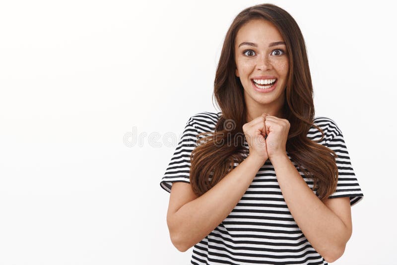 Sorprendida jovencita excitada y linda coja manos juntas, sonriendo entretenida, no puede creer que tenga suerte ganadora, triunf fotografía de archivo libre de regalías