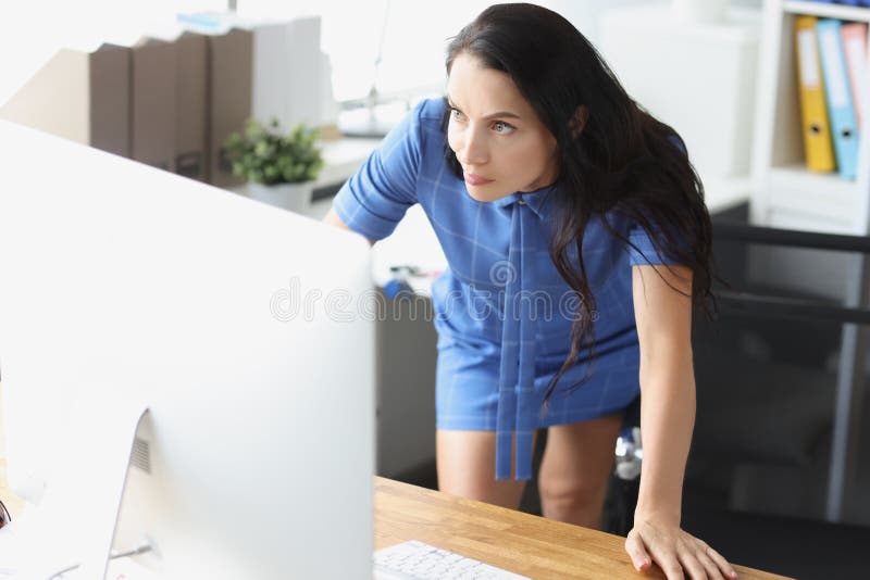 Sorprendida mujer disgustada mirando al monitor de computadora en el lugar de trabajo