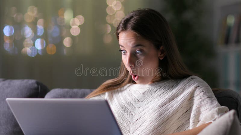 Sorprendida mujer encontrando noticias asombrosas en una laptop