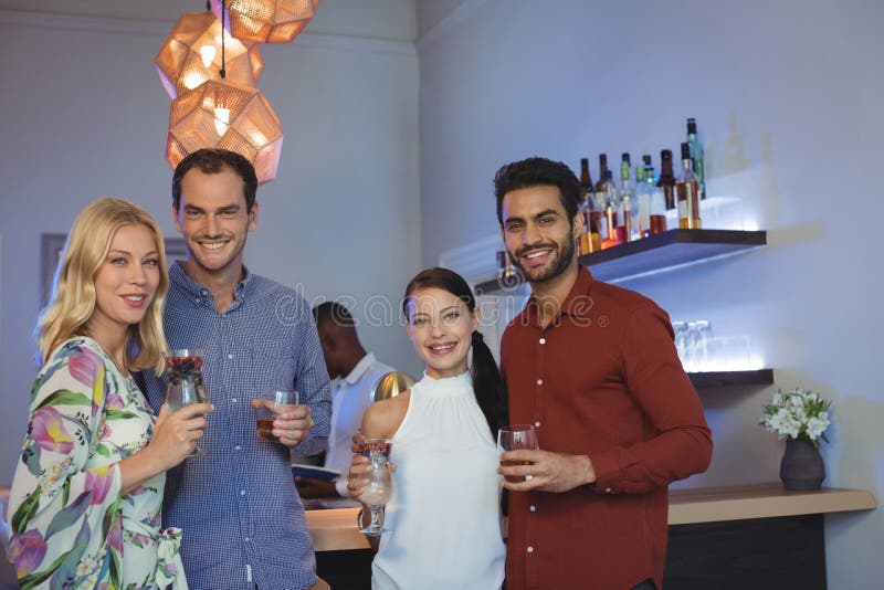 Sorridendo due coppie che hanno cocktail insieme nel ristorante della barra immagini stock libere da diritti Sorridendo due coppie che hanno cocktail insieme nel ristorante della barra immagini stock libere da diritti