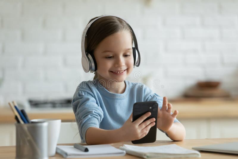 Sorridente menina deitada no sofá confortável, gostando de jogar