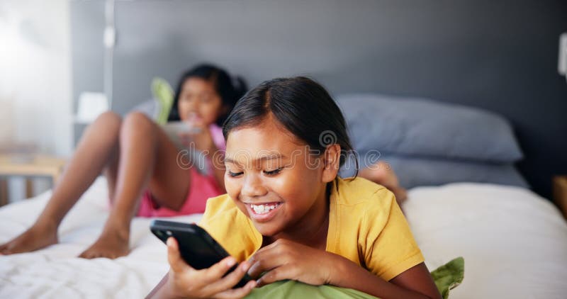 Sorridi bambino e rilassati con il telefono in camera su social media guardando fumetti e servizi in streaming. Felice ragazza e immagini stock libere da diritti