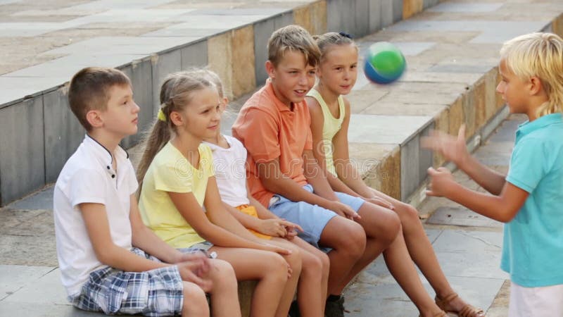 Sorrir caçoa na idade escolar que tem o divertimento que joga a bola junto