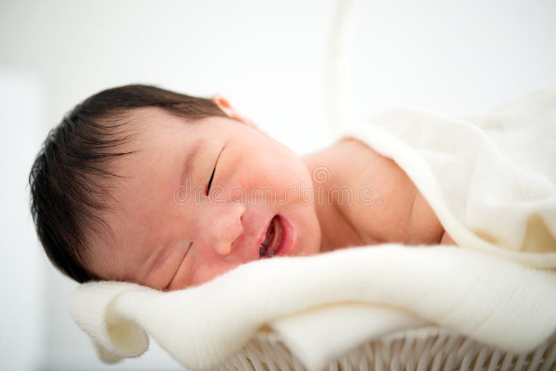 Sorriso asiático recém-nascido do bebê