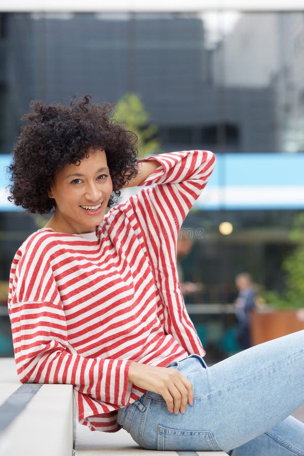 Sorriso de assento atrativo da mulher mais idosa fora foto de stock Sorriso de assento atrativo da mulher mais idosa fora foto de stock