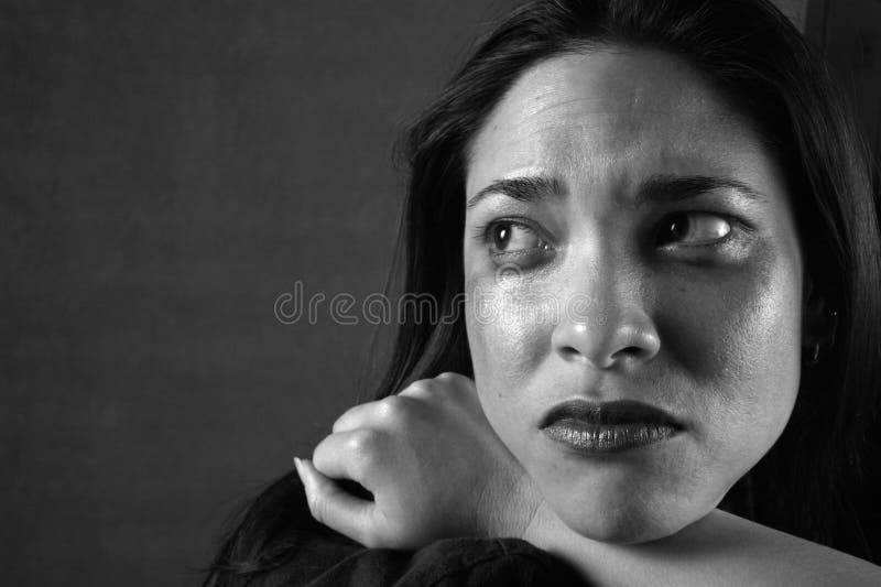 Eine junge Frau sitzt weinend.